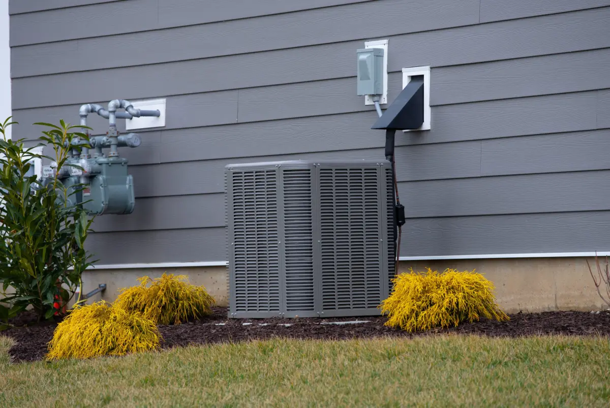 Outdoor AC condenser unit beside a house