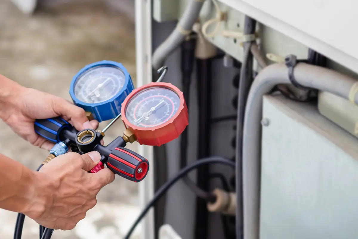 Technician checking refrigerant pressure with a gauge set
